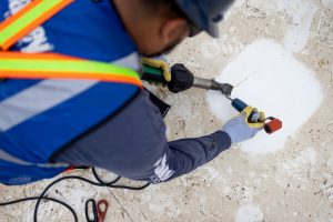 Man patching a hole on a roof. smartCARE roof maintenance.
